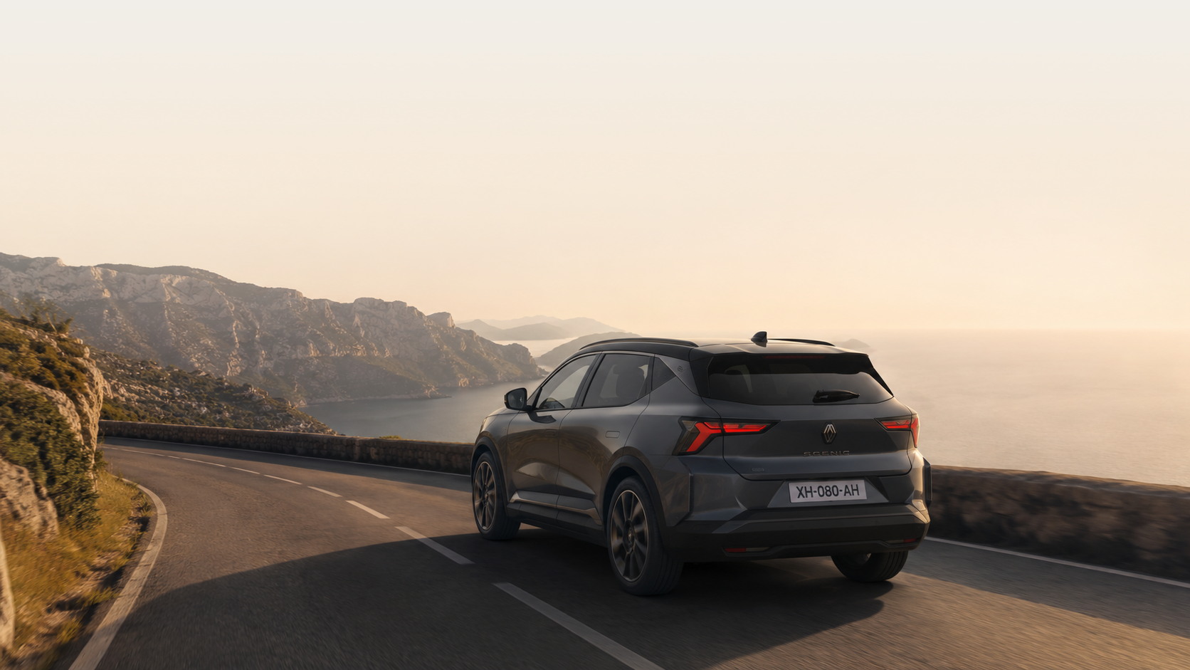 Renault Scénic E-Tech on a coastal road at sunset